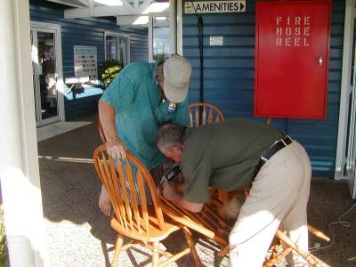 Brad carves Shear Madness onto a chair