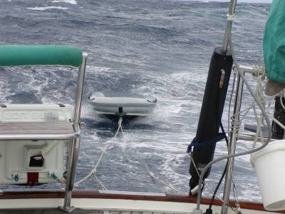 The dinghy Insanity being towed right side up! 